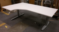 Skrivebord med elektrisk hevsenk i hvitt fra Kinnarps, 180x120cm, ventresløsning, pent brukt understell med ny plate