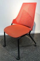 Enkel stablestol på hjul, sete i rødt stoff, rygg i rød plast, sort metallunderstell, brukt med slitasje/smuss