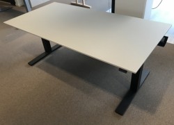 Skrivebord med elektrisk hevsenk fra Kinnarps, beige bordplate, sort understell, 160x80cm, pent brukt