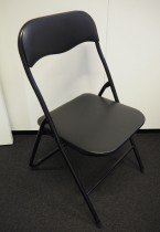 Enkel klappstol i sort kunstskinn / sortlakkert metall, pent brukt