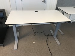 Skrivebord med elektrisk hevsenk, 140x75cm i hvitt med sort kant, grått understell, pent brukt