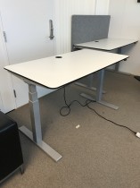 Skrivebord med elektrisk hevsenk, 140x75cm i hvitt med sort kant, grått understell, pent brukt