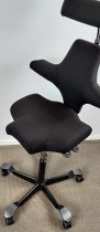 Ergonomisk kontorstol: Håg Capisco 8107 i sort stoff, sort fotkryss, 69cm sittehøyde, nakkepute, NYTRUKKET, pent brukt