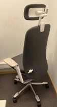 Kontorstol fra Kinnarps: Modell Capella i mørkt grått stoff, høy rygg, armlener, nakkepute i sort skinn, polert alu kryss, pent brukt